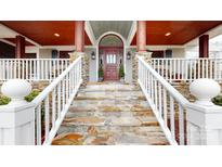 Inviting home entrance with stone steps, white railings, and a charming wood door with sidelights at 13031 Westmoreland Farm Rd, Davidson, NC 28036