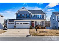 Two-story house with gray siding, red door, and three-car garage at 6270 Durango Way, Denver, NC 28037