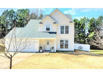 Charming two-story home featuring a manicured lawn, white trim, and an inviting front porch with rocking chairs at 712 Georgie St, Troutman, NC 28166