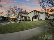 Two-story house with light green siding, landscaping, and a sidewalk at 15305 Colonial Park Dr, Huntersville, NC 28078