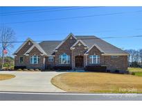 Charming brick home featuring manicured landscaping and a horseshoe driveway at 341 Canvasback Rd, Mooresville, NC 28117