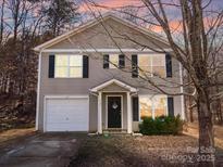 Charming home featuring a classic exterior with a single-car garage and well-maintained landscaping at 1107 Stonehenge Ln, Charlotte, NC 28216