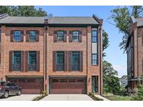 Brick front exterior of a three-story townhome with a two-car garage at 2549 Vail Ave, Charlotte, NC 28207