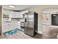 Modern kitchen featuring white cabinets, stainless steel appliances, and stylish herringbone backsplash at 2829 1St Nw Ave, Hickory, NC 28601