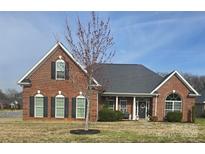 Charming brick home with a manicured lawn and a welcoming front porch at 5421 Roberta Meadows Ct, Concord, NC 28027