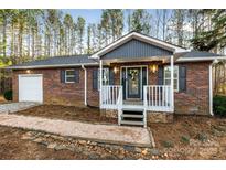 Brick ranch house with gray accents, front porch, and landscaped walkway at 210 Liz Cortland Rd, China Grove, NC 28023