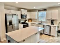 Bright and modern kitchen featuring stainless steel appliances, white cabinetry, and a center island at 505 Grandiflora Ave, Lancaster, SC 29720