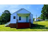 White house with red base, front porch, and steps leading to the front door at 556 6Th St, Chester, SC 29706