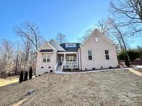 Charming brick home featuring manicured landscaping and a welcoming front porch at 7667 Maple Bluff Ln # 53, Concord, NC 28025