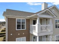 Charming condo exterior featuring a cozy balcony with white railings and a well-maintained brick facade at 9027 Mcdowell Creek Ct, Cornelius, NC 28031