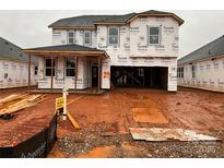 New construction home featuring a covered entry and attached two-car garage in an active construction zone at 1016 Farm Branch Ct, Indian Trail, NC 28079