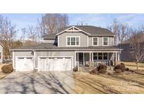 Two-story house with gray siding, three-car garage, and a front porch at 174 Country Lake Dr, Mooresville, NC 28115