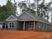 Charming one-story home with gray siding, a covered porch, and well-manicured landscaping at 211 Benfield Rd, Kings Mountain, NC 28086