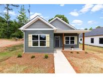 Charming single-story home with gray siding, wood accents, and a welcoming front porch at 211 Benfield Rd, Kings Mountain, NC 28086