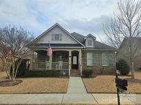 Brick ranch home with stone accents, covered porch, and landscaped yard at 240 Harrison Ln, Locust, NC 28097