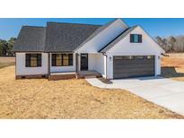 White farmhouse exterior with dark gray garage door and landscaping at 343 North Brook Iii School Rd, Vale, NC 28168