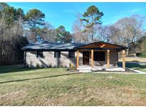 Brick ranch home with covered porch and landscaped lawn at 4165 Laurelwood Ct, Concord, NC 28025