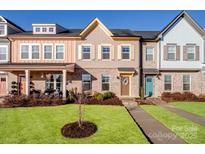 Three-story townhome with brick and siding, front porch, and landscaped lawn at 674 Dunkins Ferry Rd, Rock Hill, SC 29730