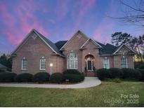 Brick home with landscaped yard and walkway at 210 Classic Ct, Mount Holly, NC 28120