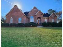 Brick house with manicured lawn and landscaping at 210 Classic Ct, Mount Holly, NC 28120