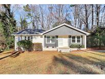 Charming single-story home featuring a gray and white painted brick exterior with a well-maintained front lawn at 4321 Gillespie Ct, Charlotte, NC 28205