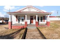 Charming home featuring a welcoming front porch with brick accents and benches at 601 N 12Th St, Bessemer City, NC 28016