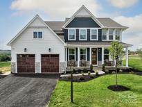 Two-story house, white and blue siding, two-car garage, and a landscaped lawn at Lot 12 Mayes Meadow Dr # Magnolia, Cornelius, NC 28078