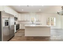 Modern kitchen with white cabinets, granite countertops, and stainless steel appliances at 1135 Rudder Cir, Salisbury, NC 28146