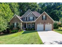 Charming two-story brick home with a well-manicured lawn, two-car garage, and welcoming front porch at 122 Ardmore Pl, Mooresville, NC 28117