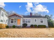 Charming gray house with orange door, landscaping, and a well-maintained lawn at 1715 Dunkirk Dr, Charlotte, NC 28203