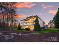 Stunning lakefront home with multiple balconies overlooking the water during a colorful sunset at 237 Wilson Lake Rd, Mooresville, NC 28117