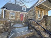 Charming stone home featuring a red front door, stone steps, and manicured landscaping at 330 E Main St, Albemarle, NC 28001