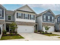 Modern townhome with a two-car garage, stone accents, white siding, and dark shutters for a sleek and contemporary look at 4134 Steel Way, Sherrills Ford, NC 28673