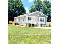 Charming single-story home boasts a well-manicured lawn and classic architectural details at 507 E Lackey Farm Rd, Stony Point, NC 28678
