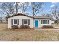 Charming ranch home with a teal front door and landscaped yard at 809 Hasty Rd, Marshville, NC 28103