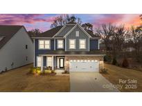 Charming two-story home with a brick facade, a well-manicured lawn, and a two-car garage at 8138 Annsborough Nw Dr, Concord, NC 28027