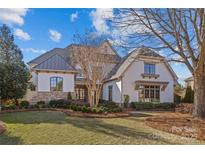 Two-story house with stone accents and a metal roof, showcasing a well-manicured lawn at 8904 Clavemorr Glenn Ct, Charlotte, NC 28226