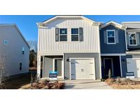 Two-story townhome with gray and white siding, a white garage door, and landscaping at 3530 Backwater St, Concord, NC 28027