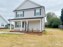 Two-story house with gray siding, a front porch, and a landscaped yard at 622 N Walnut St, Kannapolis, NC 28081