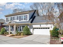 Charming two-story home with light gray brick, dark shutters, and a well-manicured front yard at 1103 N Sharon Amity Rd, Charlotte, NC 28211