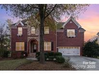 Brick two-story house with a three-car garage and landscaping at 14226 Carlton Woods Ln, Charlotte, NC 28278