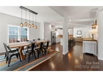 Open dining room featuring a large wooden table with decorative lighting and hardwood floors at 212 Bacon Ave, Charlotte, NC 28208