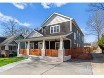 Charming two-story home with a welcoming front porch and wooden fence at 212 Bacon Ave, Charlotte, NC 28208