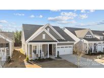 Charming single-Gathering home featuring a covered front porch with rocking chairs and a two-car garage at 240 Portrait Way # 87, Indian Trail, NC 28079