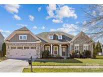 Gray house with stone accents, two-car garage, and landscaped lawn at 3027 Arsdale Rd # 75, Waxhaw, NC 28173