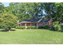 Charming brick home with a welcoming front porch and lush green lawn at 7740 Robinson Church Rd, Charlotte, NC 28215