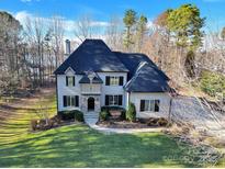 Charming two-story home with manicured lawn and mature trees, offering classic curb appeal and inviting entrance at 107 E Cold Hollow Farms Dr, Mooresville, NC 28117