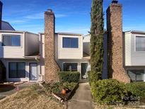 Inviting exterior of charming brick townhouse with well-manicured landscaping at 10945 Carmel Crossing Rd, Charlotte, NC 28226