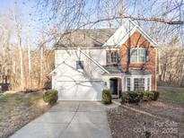 Two-story brick home with attached garage and landscaped yard at 13443 Norseman Ln, Huntersville, NC 28078