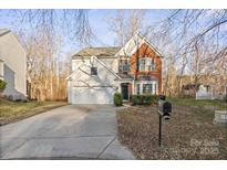 Two-story brick home with attached garage and landscaping at 13443 Norseman Ln, Huntersville, NC 28078